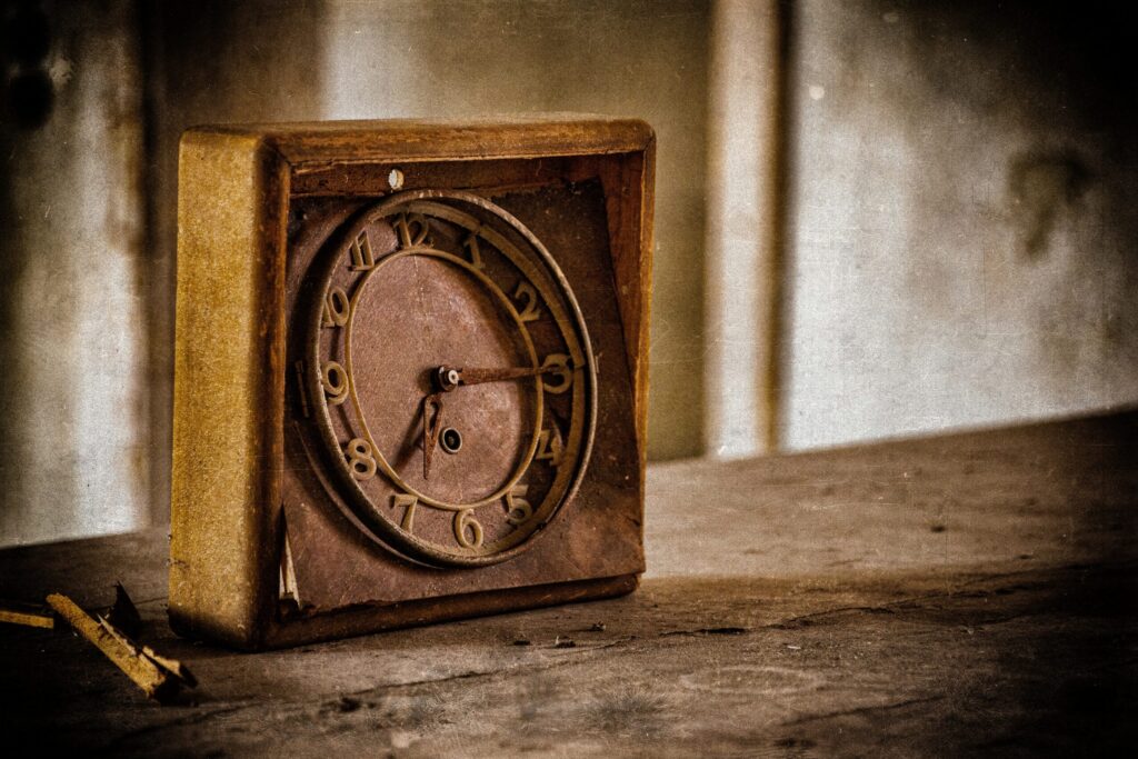 A wooden broken old clock on a shelf
